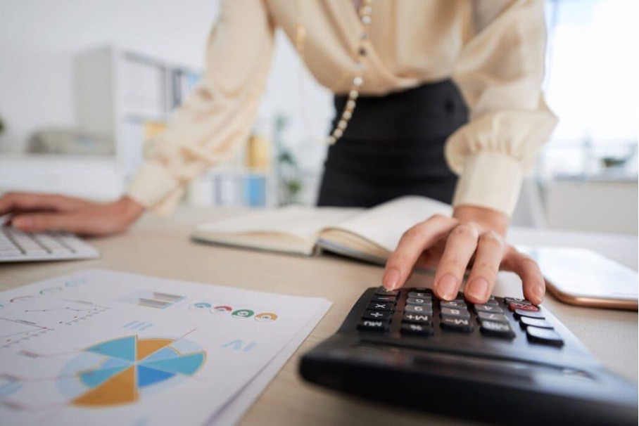 Emprendedora utilizando una calculadora para revisar sus cifras